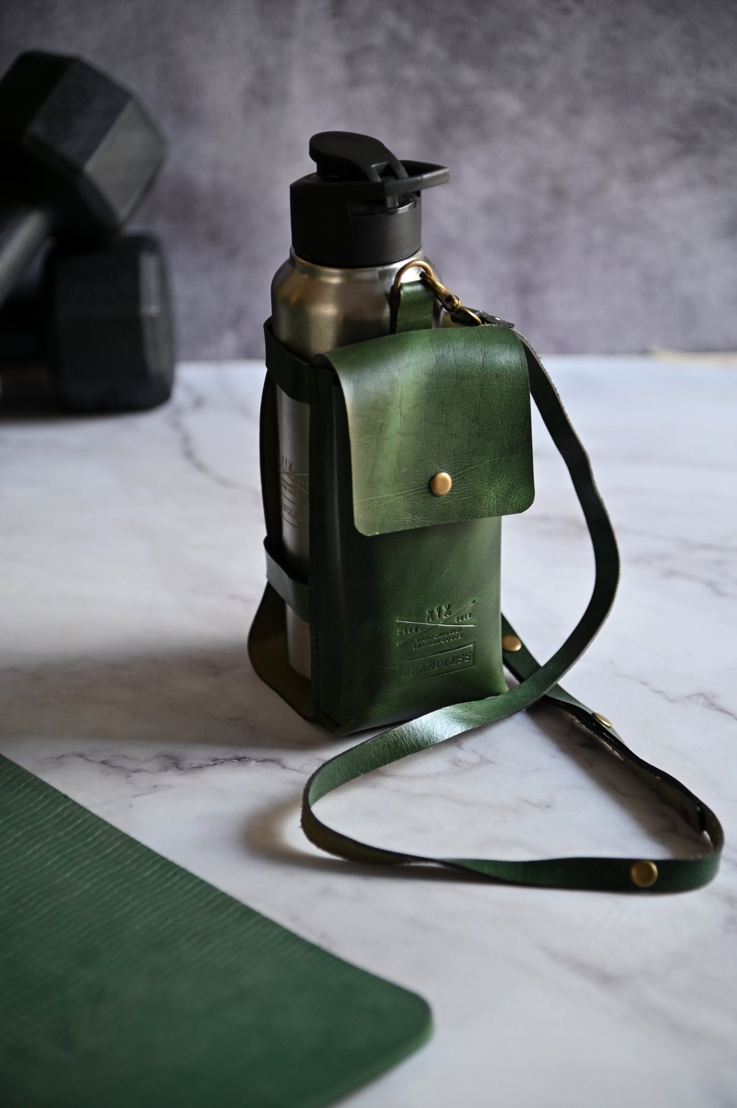 Dark Green handcrafted leather bottle case with utility pocket and steel flask, worn crossbody