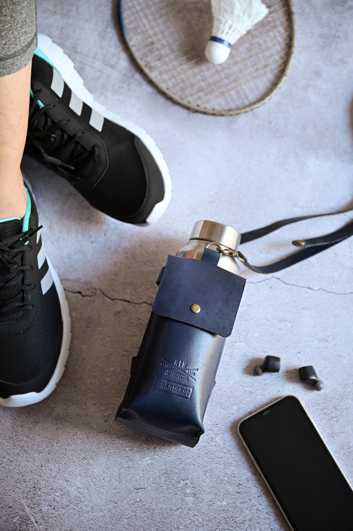 Midnight Blue handcrafted leather bottle case with utility pocket and steel flask, worn crossbody