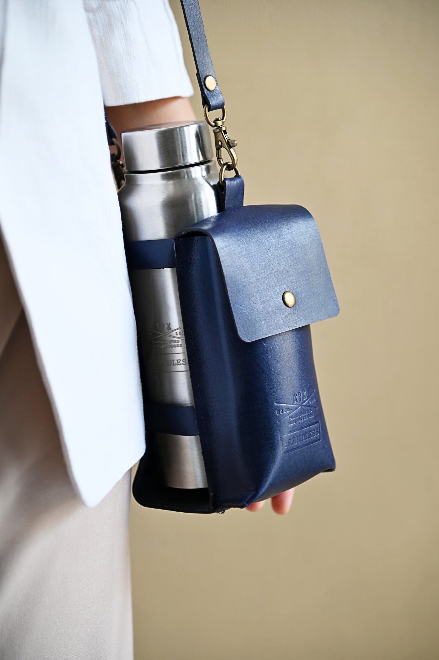 Midnight Blue handcrafted leather bottle case with utility pocket and steel flask, worn crossbody