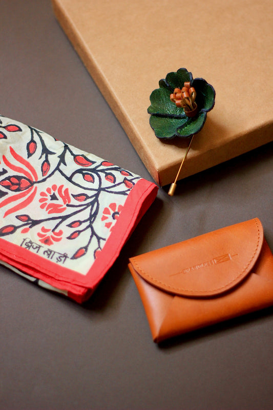 Gift hamper for men with a hand block printed silk pocket square, leather lapel pin, and leather card case.