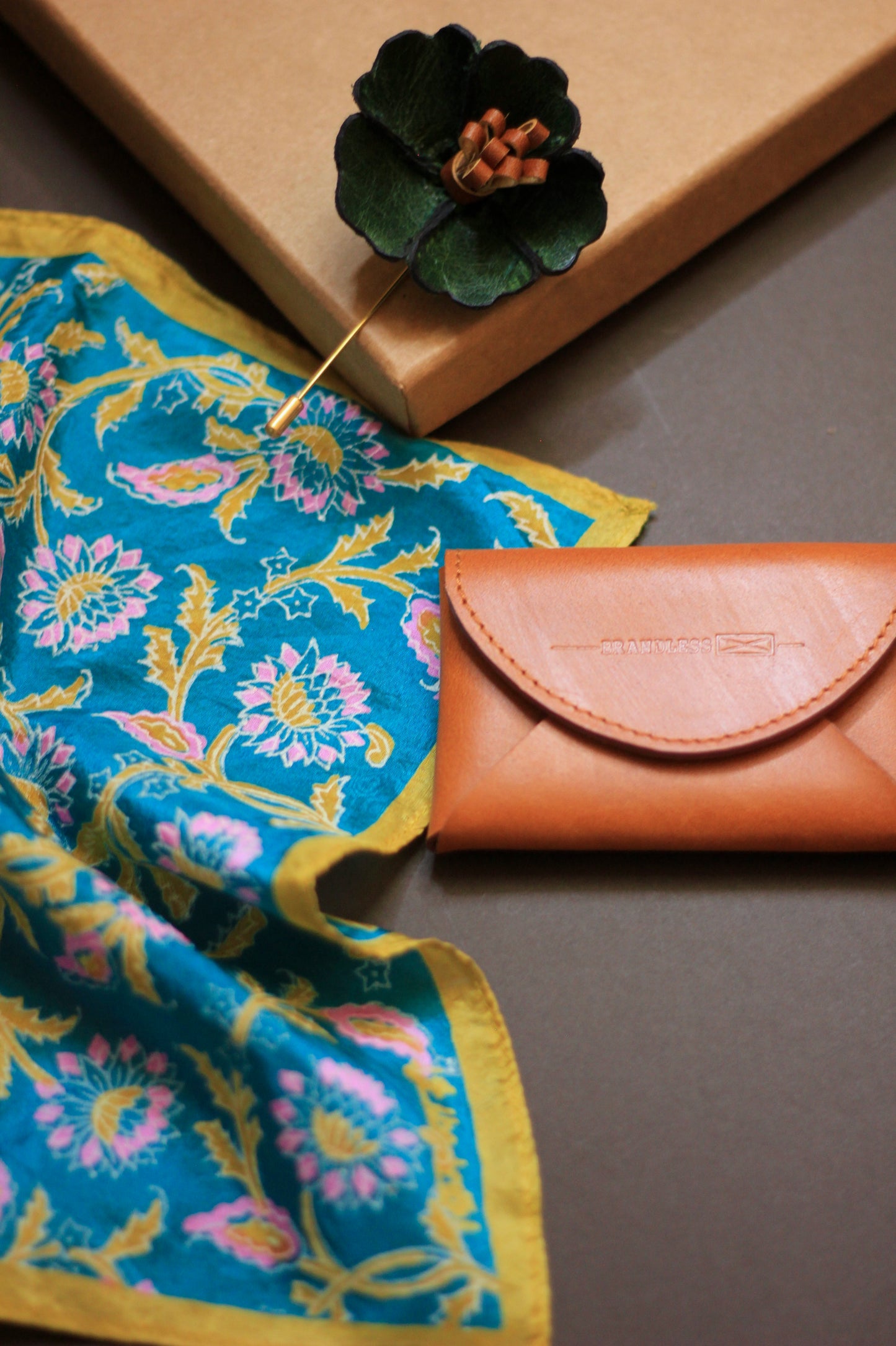 Gift hamper for men with a hand block printed silk pocket square, leather lapel pin, and leather card case.