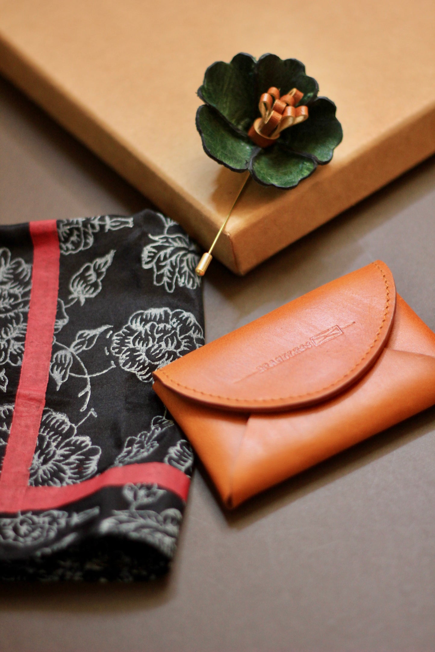 Gift hamper for men with a hand block printed silk pocket square, leather lapel pin, and leather card case.