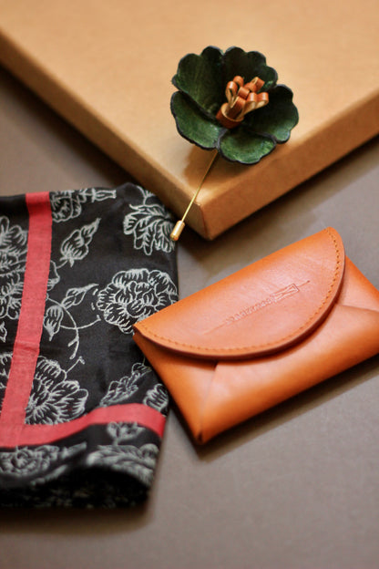 Gift hamper for men with a hand block printed silk pocket square, leather lapel pin, and leather card case.
