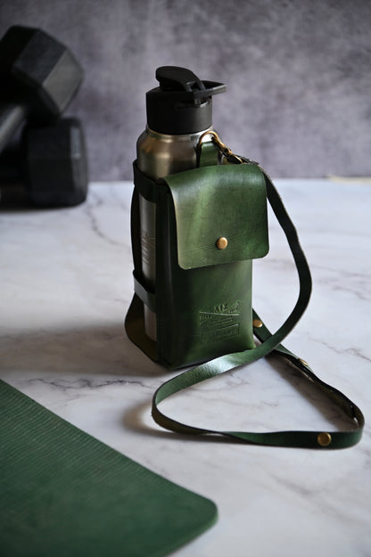 Dark Green handcrafted leather bottle case with utility pocket and steel flask, worn crossbody